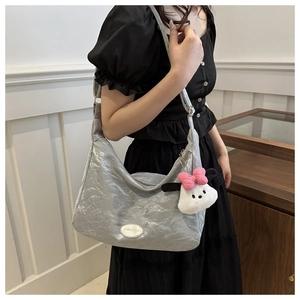 Détail du sac hobo plissé gris clair avec un charm de dessin animé en peluche