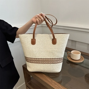 Chic woven tote bag with dark brown leather straps and large capacity for daily use