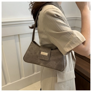 Side view of taupe baguette bag with matte texture and rectangular metal buckle