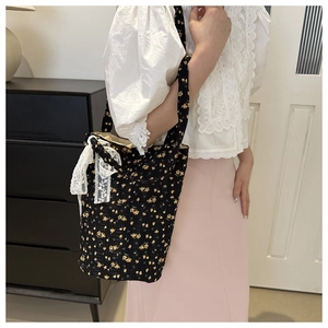Detail of floral canvas tote bag featuring delicate yellow flowers and a white lace bow accent