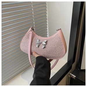 Detail of pink crescent bag featuring silver metallic bow and mirror studs decor