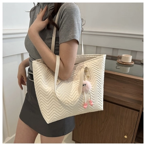 Quilted tote bag with V-shaped stitching and fashion logo including plush monster pendant