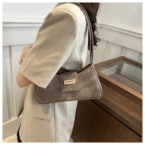 Detail of mocha brown retro underarm bag with gold metal buckle and matte leather texture