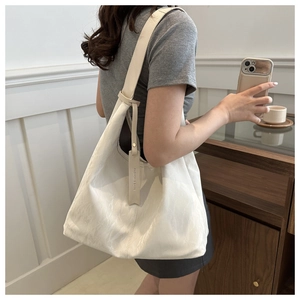 Détail du grand sac cabas crème en similicuir texturé avec étiquette de mode