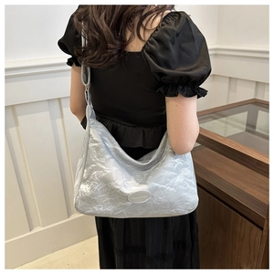 Sac à bandoulière plissé argenté montrant la texture brillante et les détails drapés
