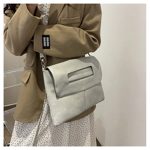 Détail du sac bandoulière enveloppe gris avec texture cuir fine et bandoulière mince