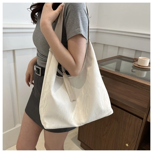 Détail du sac cabas blanc avec texture plissée et étiquette Fashion & Bags élégante