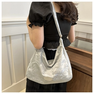 Sac hobo métallisé argenté plissé montrant l'espace intérieur et la texture