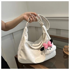 Détail du sac cabas crème en similicuir texturé avec un pendentif nuage en peluche