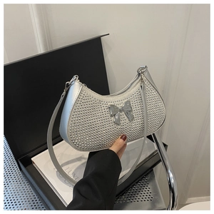 Detail of silver rhinestone half-moon shoulder bag with metallic bow buckle