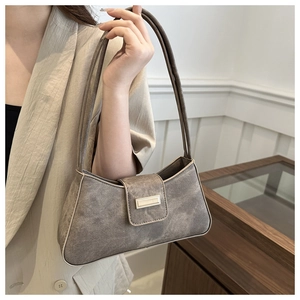 Detail view of grey vintage baguette bag featuring a metal buckle and washed canvas texture