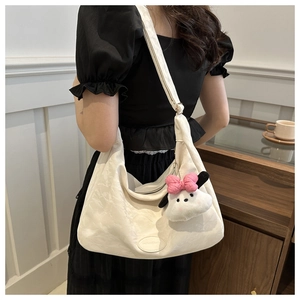 Détail du sac cabas blanc texturé avec un charmant chiot en peluche et étiquette en cuir