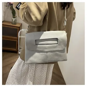 Détail d'un sac porté épaule gris à texture grainée avec une grande capacité de rangement