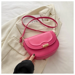 Detail of magenta saddle bag featuring a golden spiral lock and premium leather texture