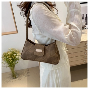 Brown vintage baguette bag with matte texture shown from a side-view on the shoulder
