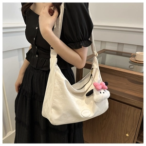 Sac bandoulière en croissant blanc avec breloque peluche et fermeture éclair épurée