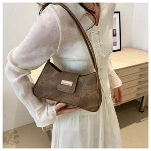 Close-up of vintage brown leather underarm bag featuring a retro cracked texture and flap