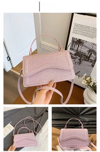 Pink woven texture handbag with gold hardware and adjustable strap in detail