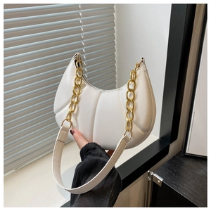 Detail of white pleated hobo bag featuring gold chain strap and textured faux leather finish