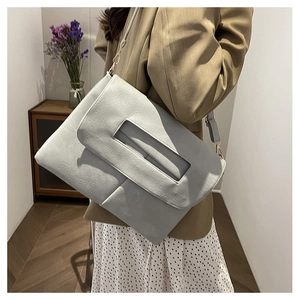Detail of light grey leather handbag showing lychee texture and rectangular handle