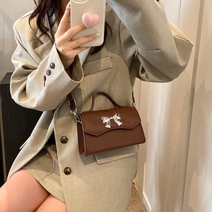 Dark brown mini crossbody bag with silver metal bow clasp and top handle for women