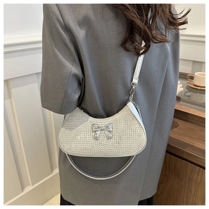 Silver rhinestone hobo bag with metal bow detail shown on a model's shoulder
