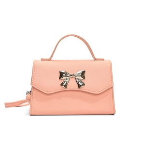 Pink crossbody bag with a golden bow detail and top handle on a white background