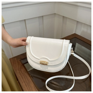 Detail of white saddle bag with smooth leather finish and golden magnetic metal buckle