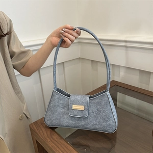 Fashionable blue textured baguette shoulder bag with gold buckle hardware and slim handle