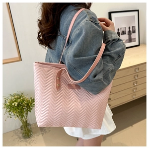 Close-up of pink quilted tote bag featuring a wave pattern and fashion label