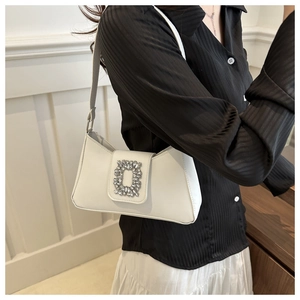 Close-up of white baguette bag featuring a luxury sparkling rectangular rhinestone buckle