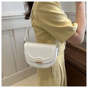 Detailed side view of white leather saddle bag with gold cylindrical metal clasp