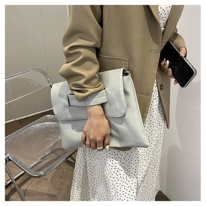 Detailed view of light gray oversized PU leather clutch bag with integrated wide hand strap