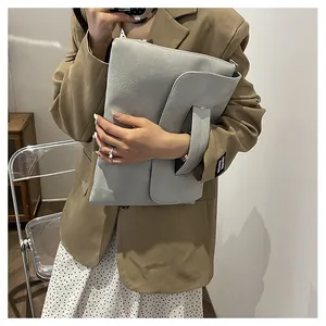 Vue détaillée du grand sac enveloppe gris clair avec texture raffinée en grain de litchi
