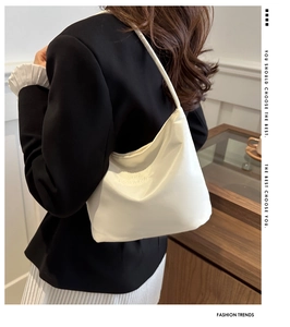 Detail of cream white nylon hobo bag featuring embossed onwards and upwards lettering