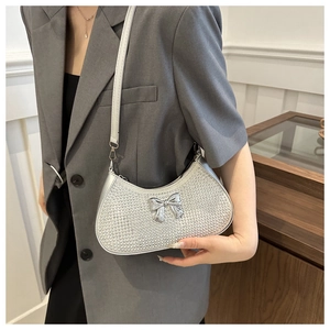 Detail of silver rhinestone half-moon bag with mirror bow and leather shoulder strap