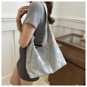 Sac fourre-tout plissé gris argenté à texture métallique porté à l'épaule en détail