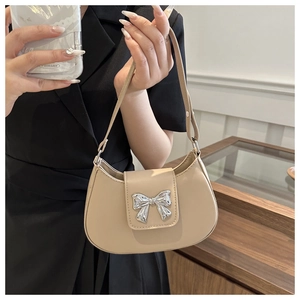 Detail of apricot shoulder bag with silver bow buckle and smooth faux leather texture