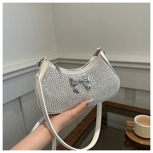 Detail of white hobo bag with sparkling silver rhinestones and a metal bow accent