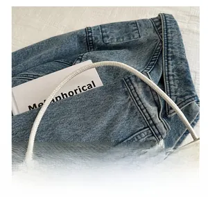 Detail of the white nylon handbag featuring slim cylindrical handles and smooth texture