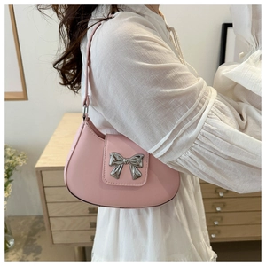 Pink hobo bag with silver bow buckle worn on shoulder with white shirt