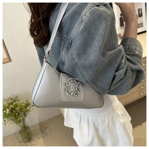 Detail view of silver grey shoulder bag with sparkling rhinestone buckle on matte leather