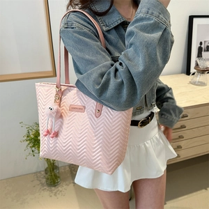Pink quilted tote bag with wave stitching and plush monster charm for women
