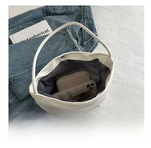 Internal view of a white bucket bag showing large capacity with magnetic closure