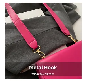 Detail of detachable wide strap with polished gold hardware hook on magenta bag