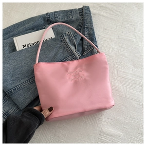 Pink satin shoulder bag with white embroidery on texturized white background cloth