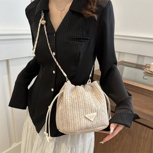 Straw bucket bag with chain strap and drawstring closure for summer fashion outfits