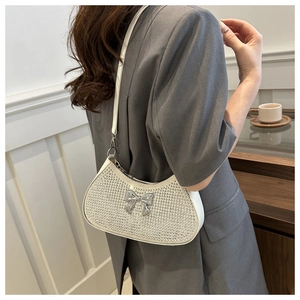 Detail of white crescent rhinestone shoulder bag with silver metallic bow decoration
