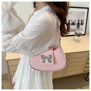 Detailed view of a pink faux leather underarm bag with a silver metal bow buckle