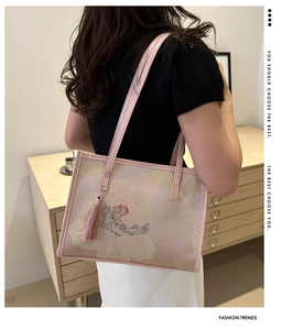 Détail du sac cabas en satin rose avec broderie florale élégante et gland en soie